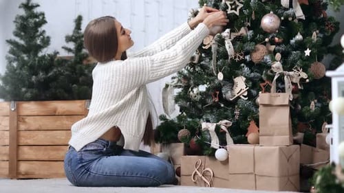 Woman Decorating Christmas Tree in Home Setting