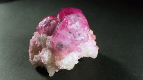 Red beryl stone in uncut raw form before finishing. Lucid crystal materials.