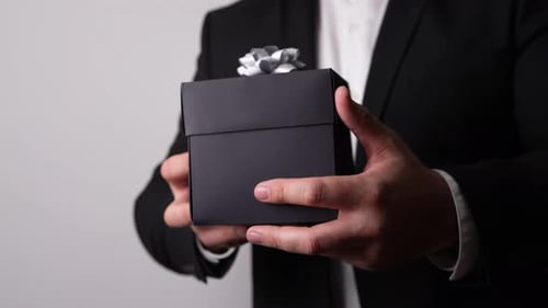 Man Holding Black Gift Box with Silver Bow