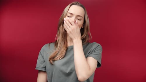 Une personne matinale décontractée bâille avec une expression mélancolique