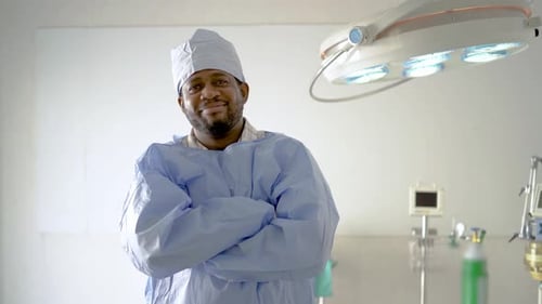 Lächelnde junge schwarze männliche Ärzte oder Chirurgen tragen eine blaue medizinische Uniform und schauen in die Kamera