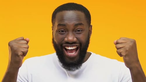 Aufgeregter afroamerikanischer Mann zeigt Ja-Geste, glücklicher Lottogewinner, Nahaufnahme