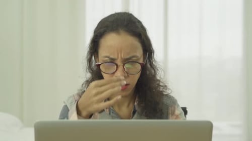 Woman Experiencing Eye Strain While Working on Laptop