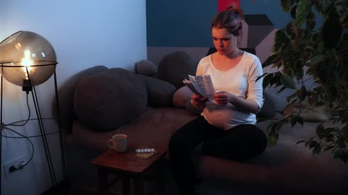 Pregnant Woman Reads Medicine Information at Night