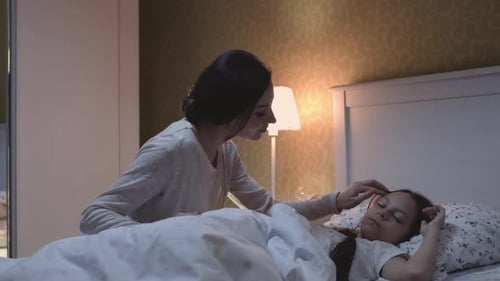 Loving Woman Watches Child Sleeping Peacefully at Night