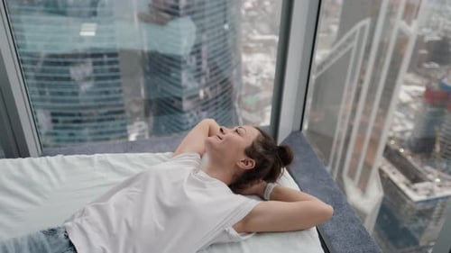 Mujer joven tranquila que duerme saludablemente durante el día durmiendo una siesta relajándose en una cama cómoda con los ojos cerrados