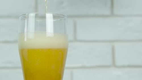 Gießen Sie ein helles Bier in das Glas.