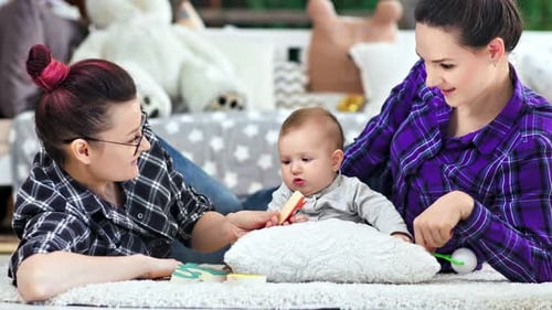 Adults and Baby Playing with Toys on Rug