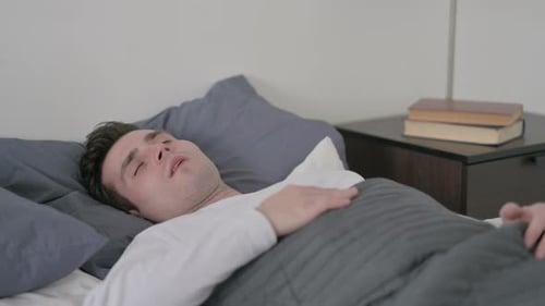 Homme se réveillant d'un cauchemar au lit