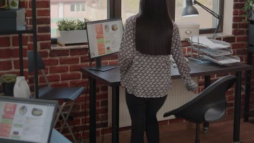 Woman Working at Computer in Brick Office