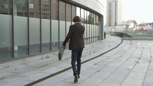 Man Walking with Briefcase in Urban Environment