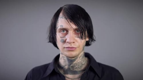 Tattooed Man with Dark Hair Looking at Camera