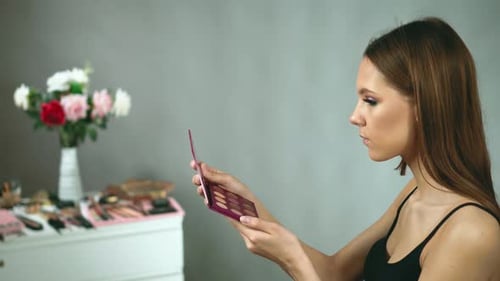 Woman Applies Makeup with Eyeshadow Palette at Home