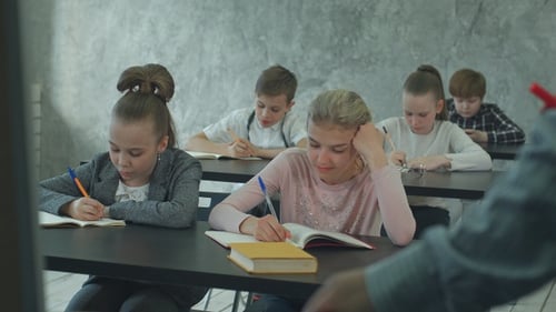 Students Writing at Desks During Class