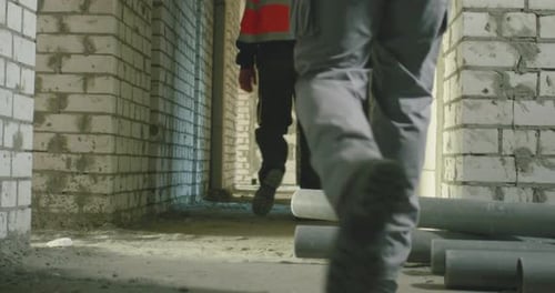 Builder Helping Fallen Colleague To Stand Up