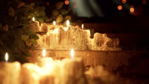 Flickering Candles with Melted Wax in a Warm, Dark Setting