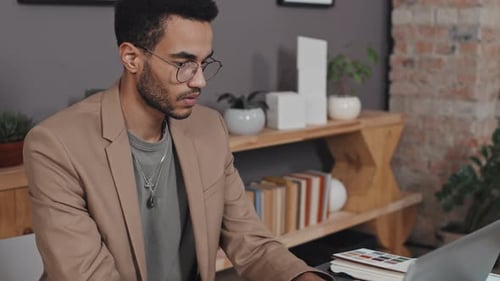 Architect Working on Laptop with Architectural Model