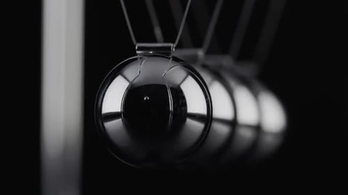 Die Kugeln einer Newtons Cradle kollidieren in Zeitlupe