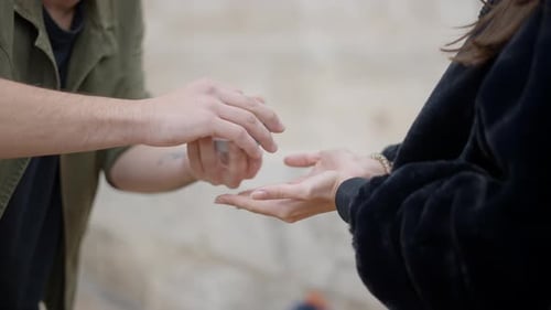 Professional Street Magician in a Cap Performs Sleight of Hand Card Trick