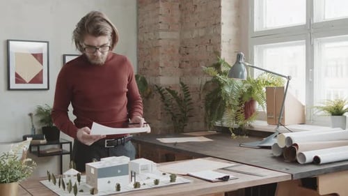 Portrait Of Male Architect Working On House Design In Office