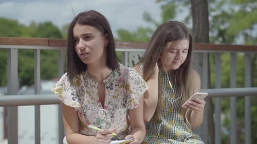 Young Women Studying Outdoors on a Sunny Day
