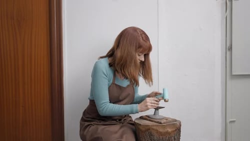 Artisan Woman Uses Rubber Hammer In Shaping Pet Jewelry In Workshop