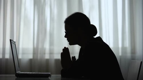 Silhouette of Adult with Laptop in Dark Room