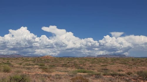 Desert Landscape with Clouds and Distant Mountains