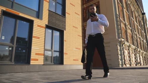 Man Walking with Phone and Briefcase in City