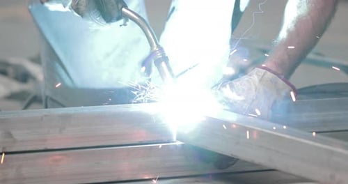 Welding Sparks As A Worker Welds Metal Frame - close up