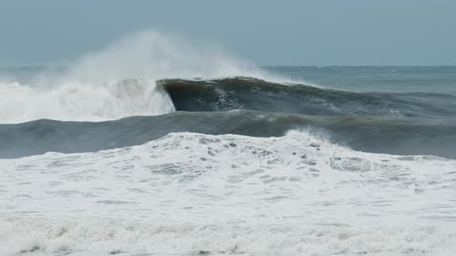 Big Wave with Foam and Dirt Breaks on the Shore During Strong Storm in the Atlantic Ocean