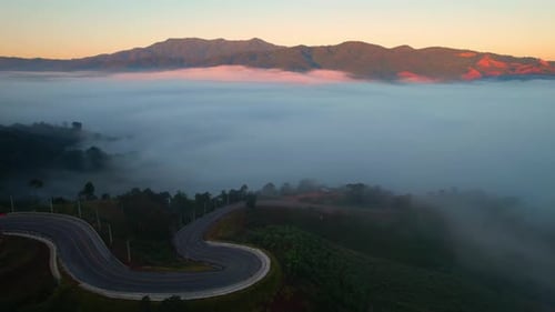 4K High mountain road in fog. Tropical forest with smoke and fog. Aerial view from drone