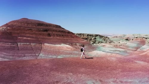 Filmmusik Luftaufnahme einer Frau, die am Reiserucksack von Red Sandstone Hills vorbeigeht