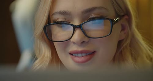 Woman Wearing Glasses is Working with Her Laptop Computer in the Cozy Cafe