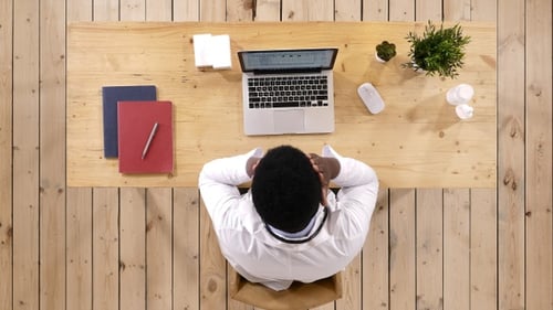 Tired doctor at his working place. Overworked and sleepy