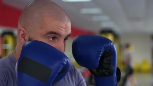 Man with Gloves Training in a Gym