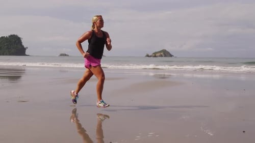 Woman running on beach, slow motion. Shot on RED EPIC for high quality 4K, UHD, Ultra HD resolution.