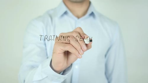 Man Writing 'Training Seminar' with Marker