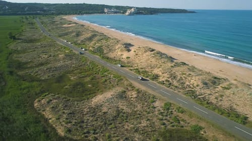 Flying Behind a Car Exploring the Coast By Driving Down a Coastal Road Near Sand Beach. Alepu