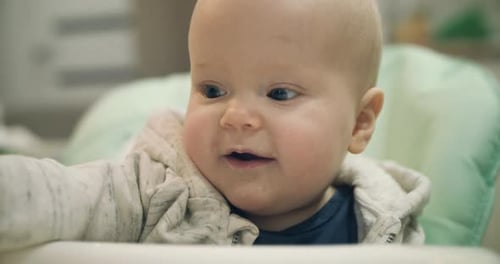 Close Portrait of Playful Infant Looking at Camera with His Beautiful Eyes