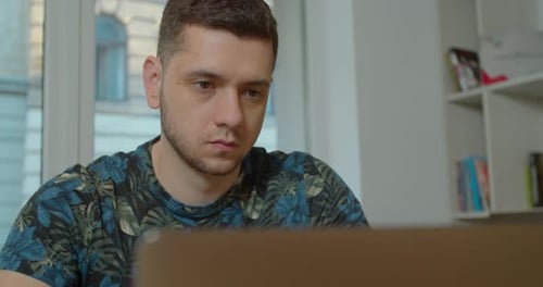 Young Man Working on Laptop Indoors, Close Up