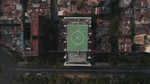 Vue aérienne aérienne de haut en bas d'un grand immeuble de bureaux avec un héliport vert sur le dessus et