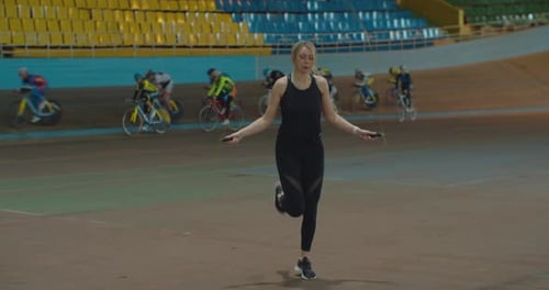 Woman Exercising with Jump Rope on Indoor Track