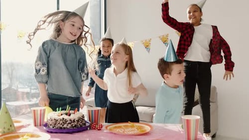 Excited Children Dancing at Birthday Party