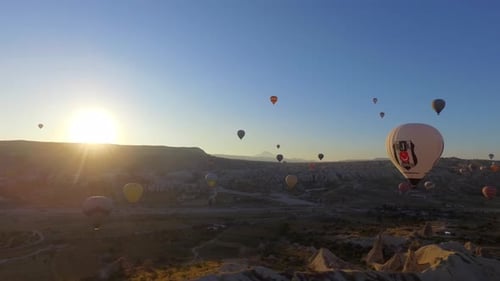 Scenic Balloons Rise Over Rugged Landscape at Sunrise