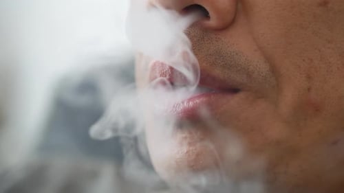 Close-Up of Adult Vaping Electronic Cigarette and Exhaling Vapor