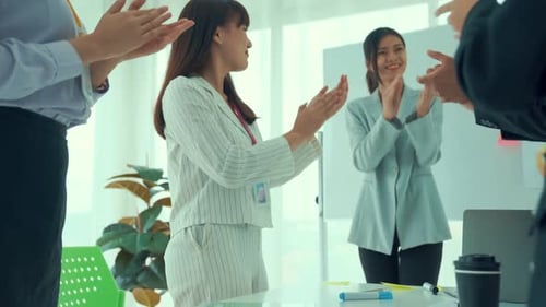 Business Team Clapping Together in Office Space