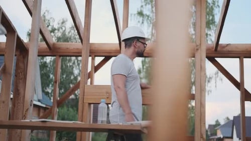A Man Walks Along the Scaffolding of the Future House