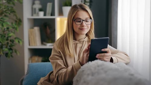 Woman Using Tablet, Relaxing at Home on Couch