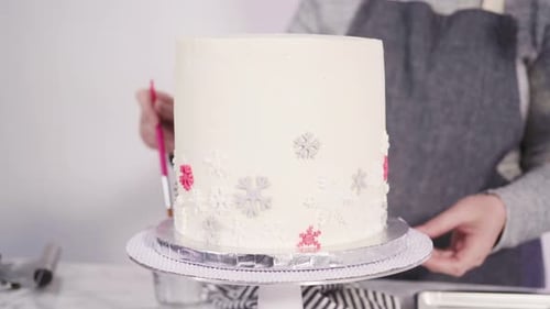 Schritt für Schritt. Runder Funfetti-Kuchen mit rosa und weißen Fondant-Schneeflocken verzieren.